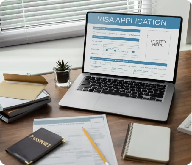 Laptop displaying a visa application form on screen, placed on wooden desk with passport, notebook, and envelope nearby